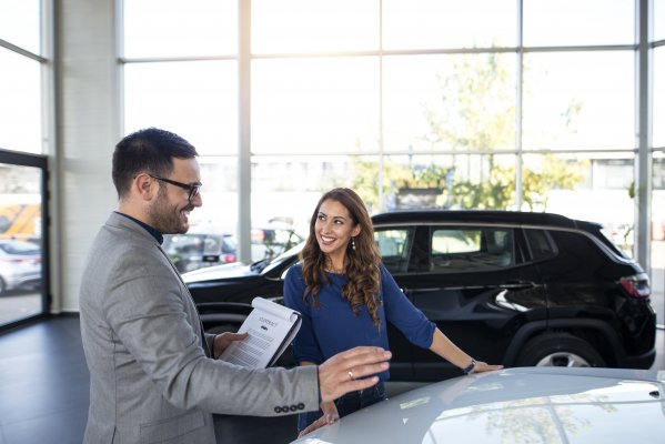 toco extended car warranty service happy woman and man in front of car signing car warranty